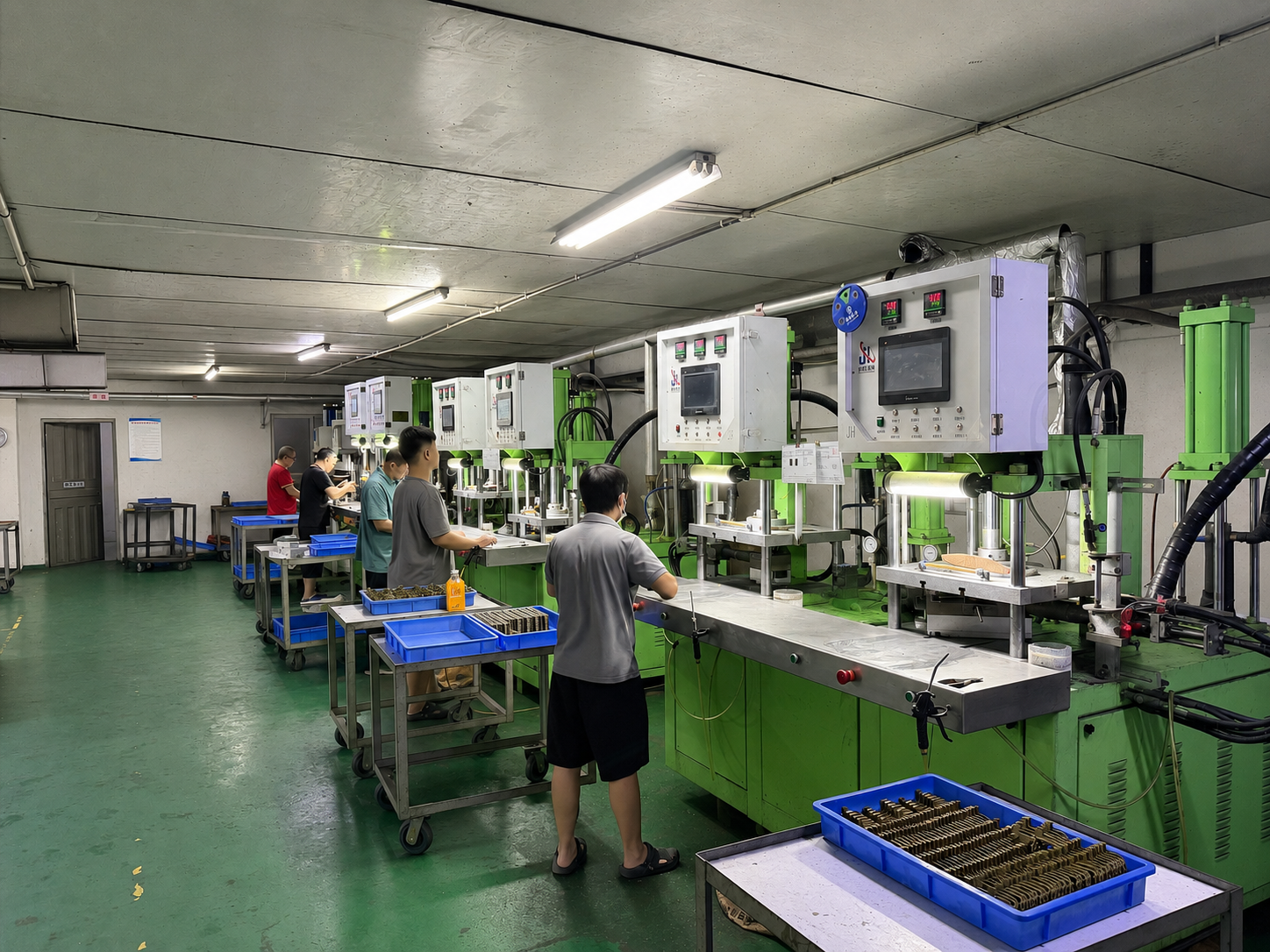 Operators working on an investment casting wax injection production line with multiple wax injection machines
